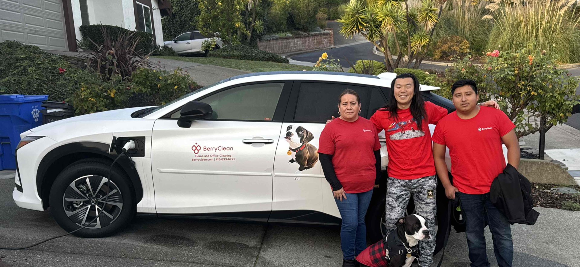 Three people stand in front of an electric vehicle they purchased for their business with an efficiency mini-grant from Intuit